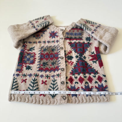 Knitted cardigan with geometric pattern and fluffy collar, measured against a white background.